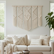 Living room with a white sofa, decorative pillows, and macrame wall art.